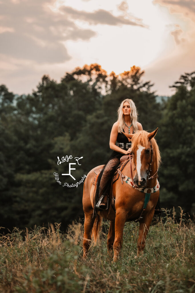 Model on horse looking left at sunset