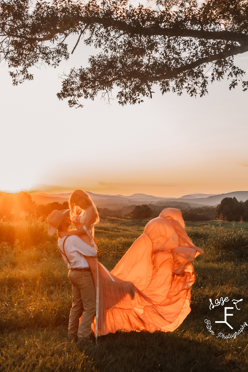 Eli lifting Payton in pink dress at sunset