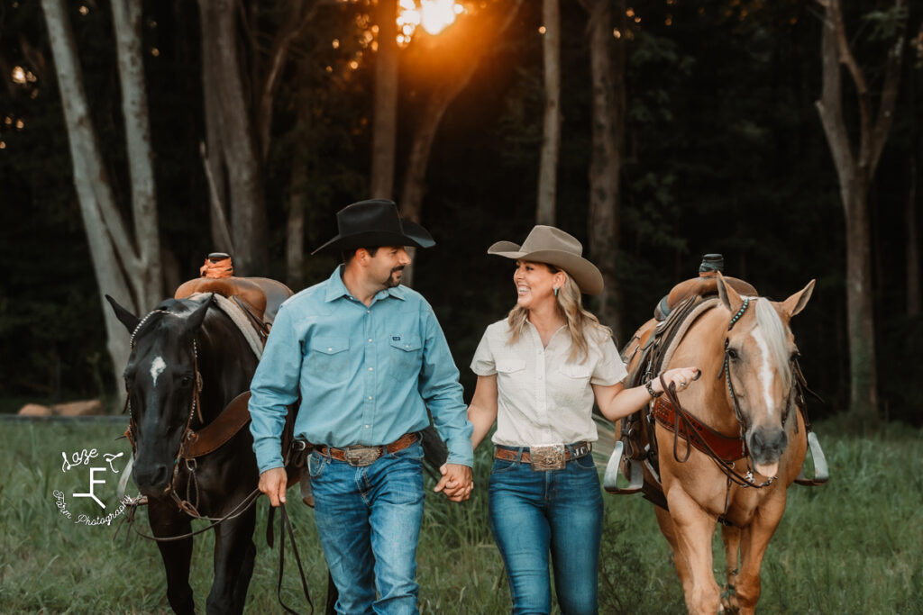 Janna and Brent walking with their horses holding hands