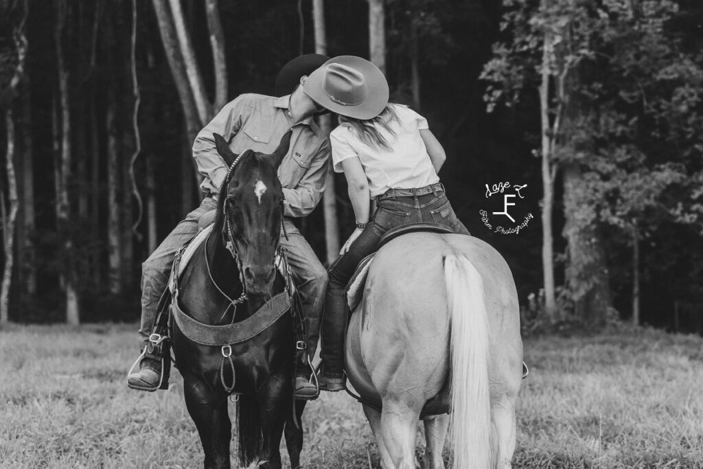 Janna and Brent kissing on horseback in black and white