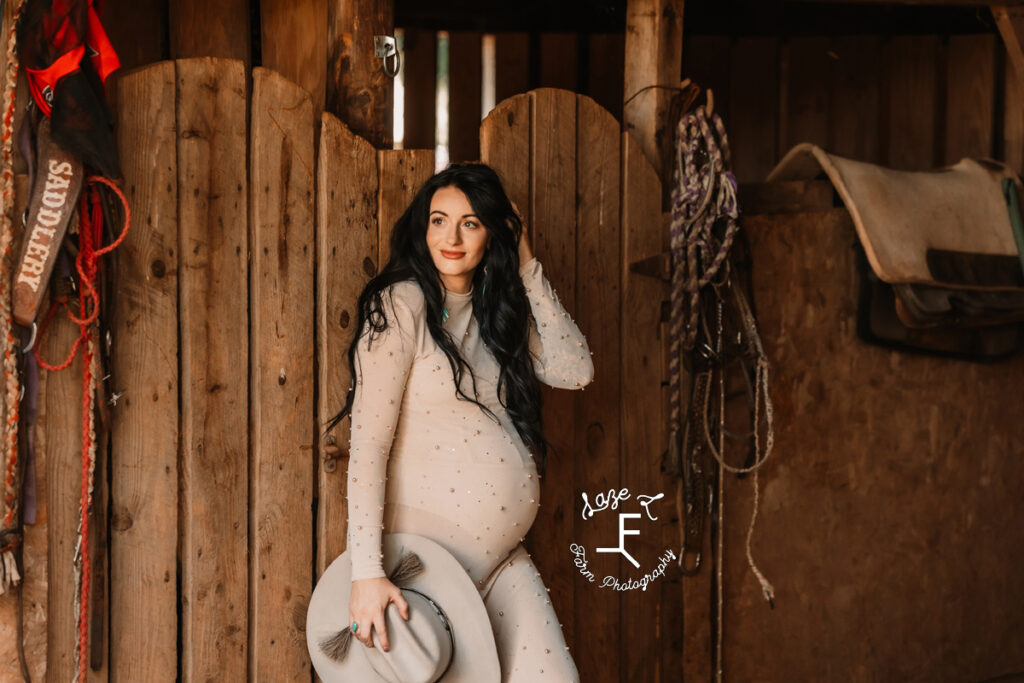 Kirstan standing in barn holding hat