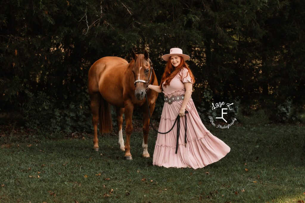 Heather in pink dress and pink hat with horse