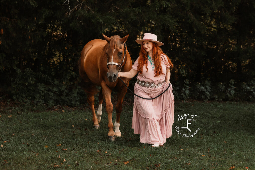 Heather walking with horse in pink dress