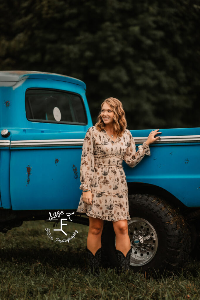 Kayla standing with old blue truck 