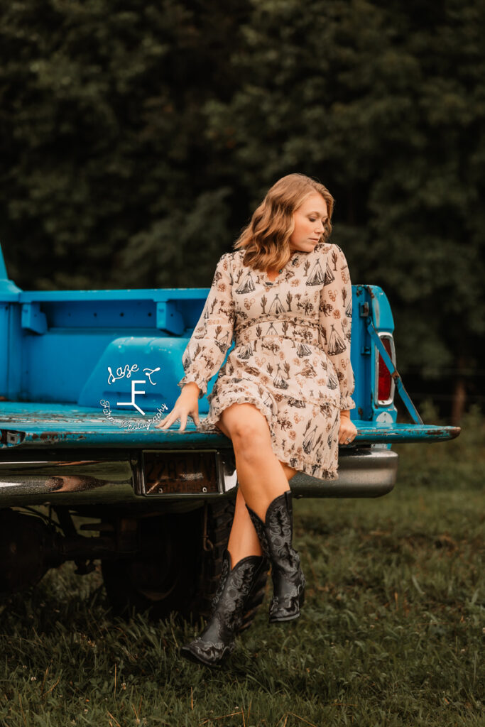 Kayla sitting on truck bed looking down