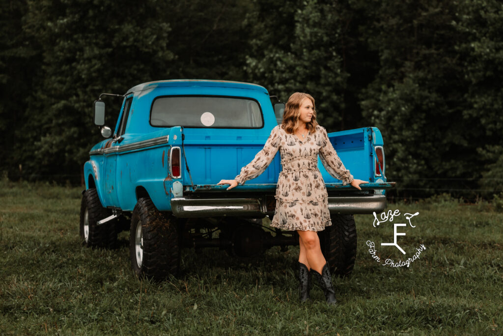 Kayla leaning on truck tailgate looking right