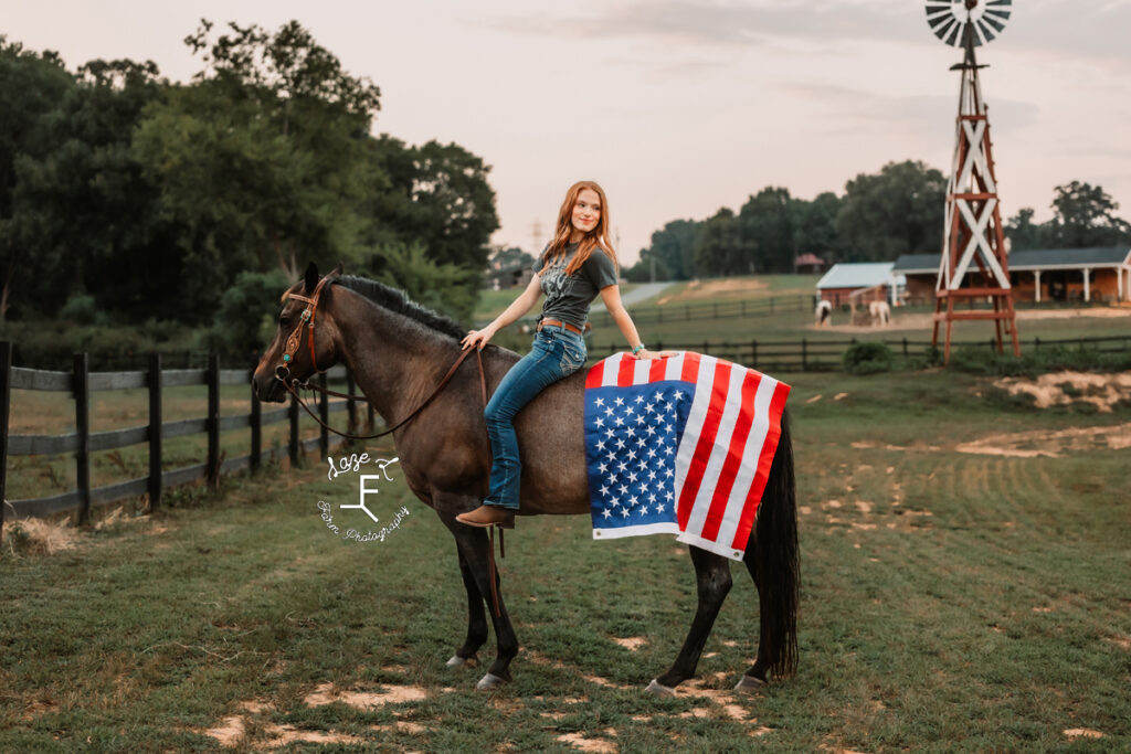 Kendall sitting on horse with American flag draped over horse