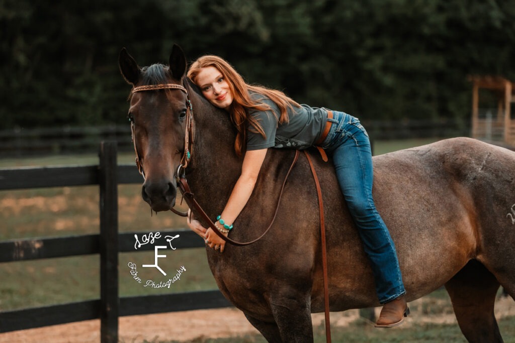 Kendall sitting on horse hugging it's neck