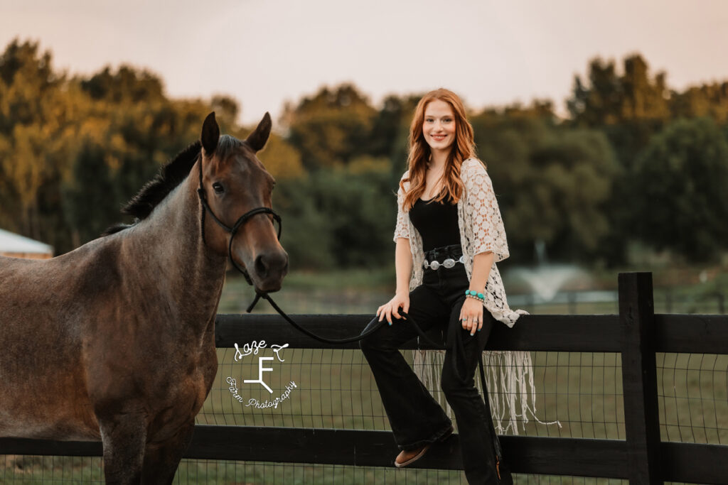 Kendall sitting on fence with horse