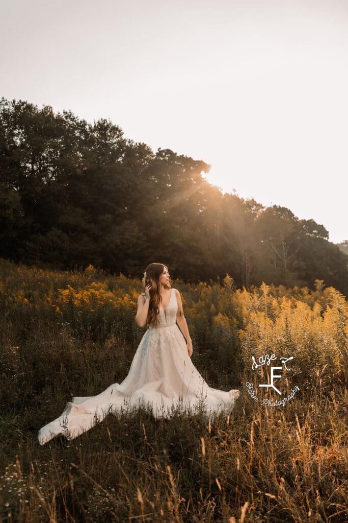 Teagan with sun behind her in field with yellow flowers