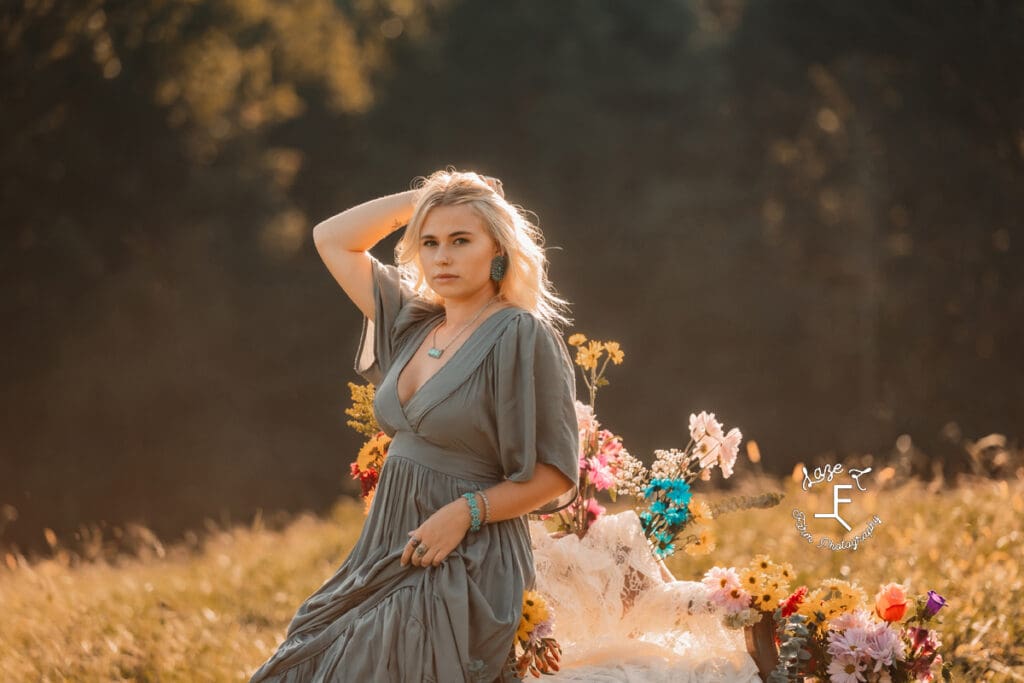 Reid in blue dress leaning against flower chair