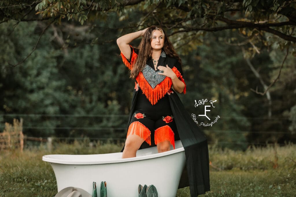 Savannah in red and black western outfit standing in tub