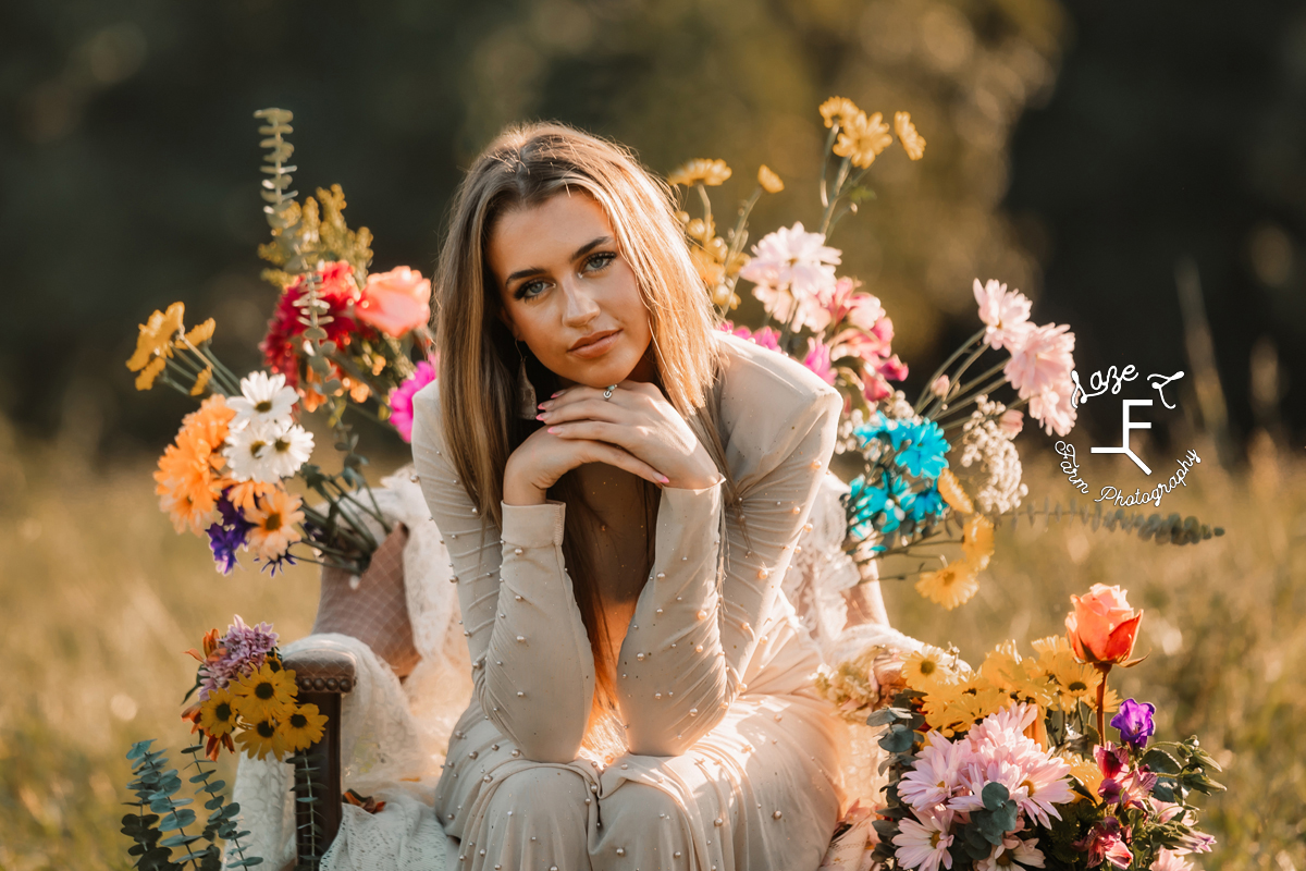 Sierra sitting with elbows propped on her knees in flower chair