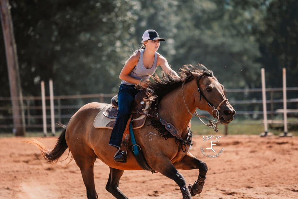 girl in black and white hat loping horse 