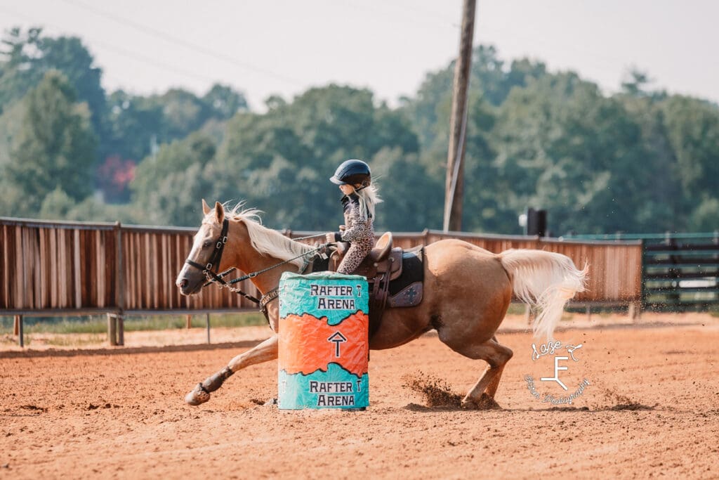 little girl on Palomino coming around barrel