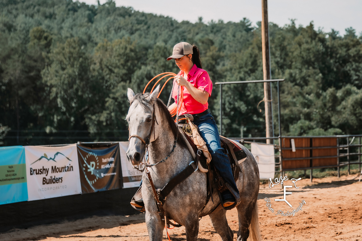 Girl on gray horse in pink shirt