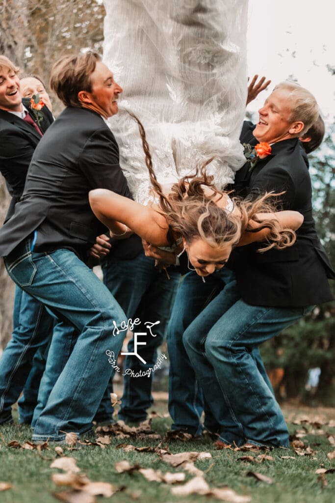 groomsmen tossing bride in the air and she almost falls