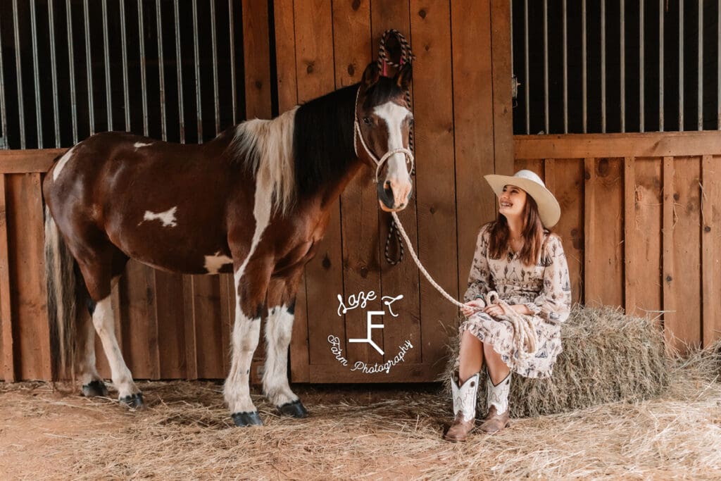 Natalie laughing holding lead rope & paint pony standing beside her