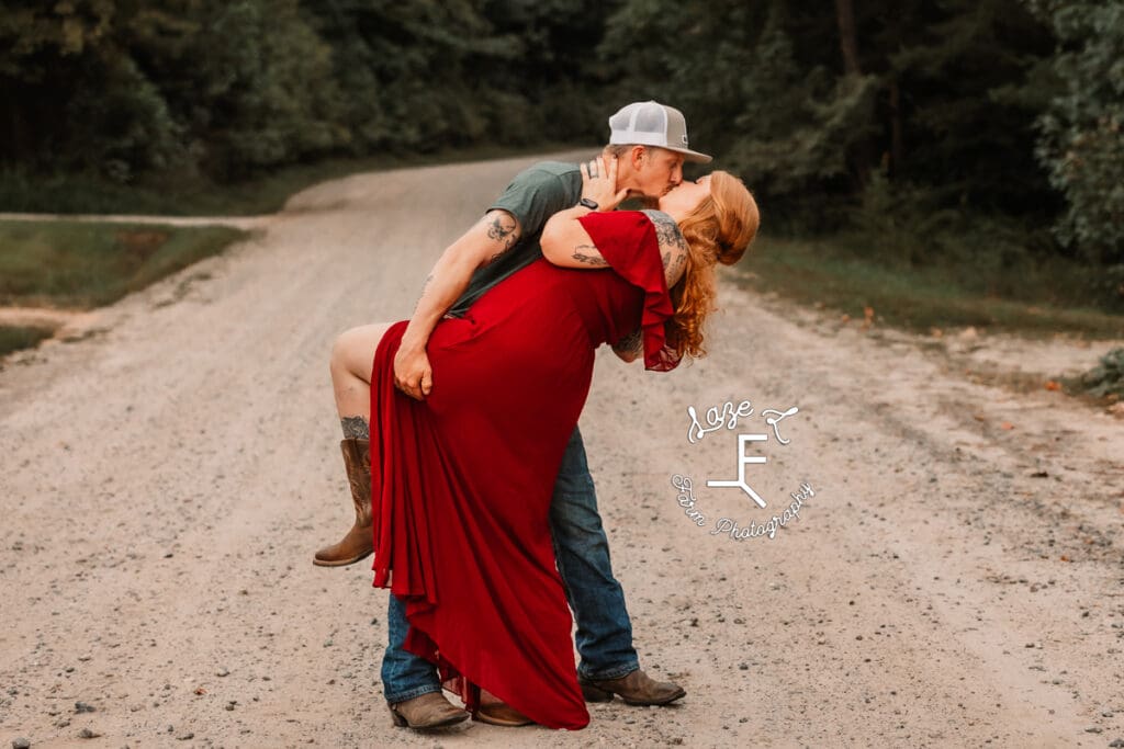 Taylor and Kyle dip kissing on a dirt road