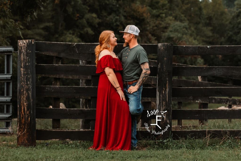 Taylor and Kyle leaning black fence looking at each other