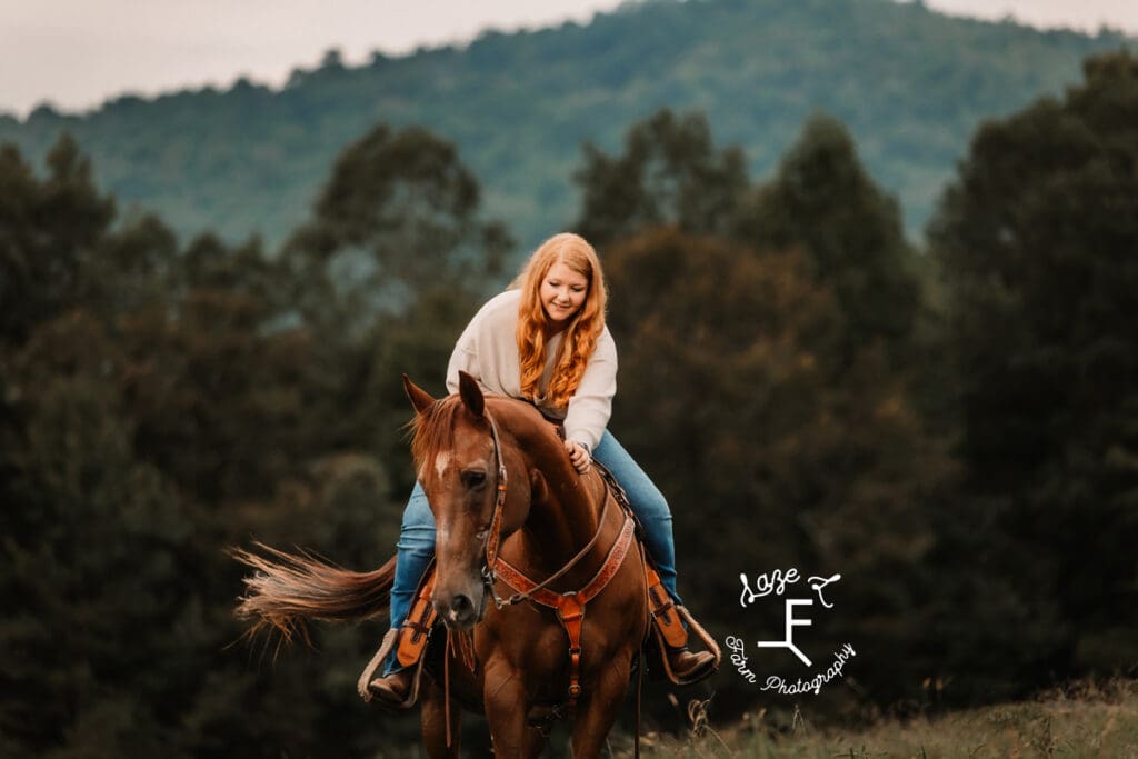 Taylor on her horse reaching down to pat its neck