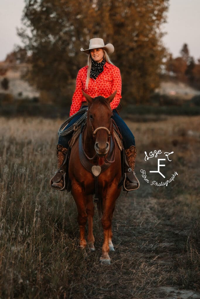 Cowgirl 1 in pink button down on brown horse