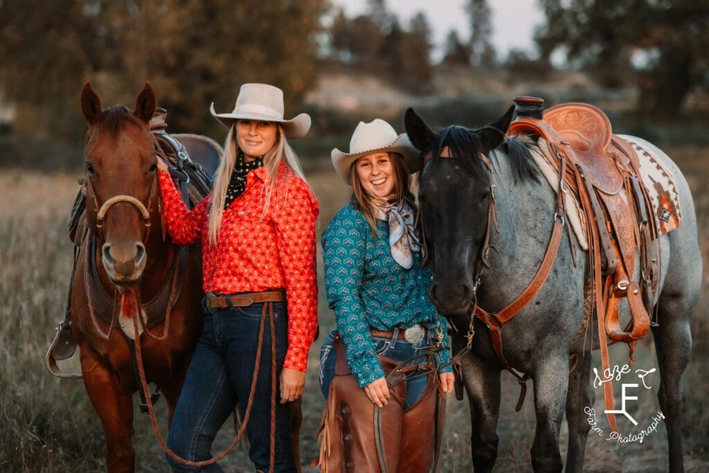 Cowgirls standing together with horses