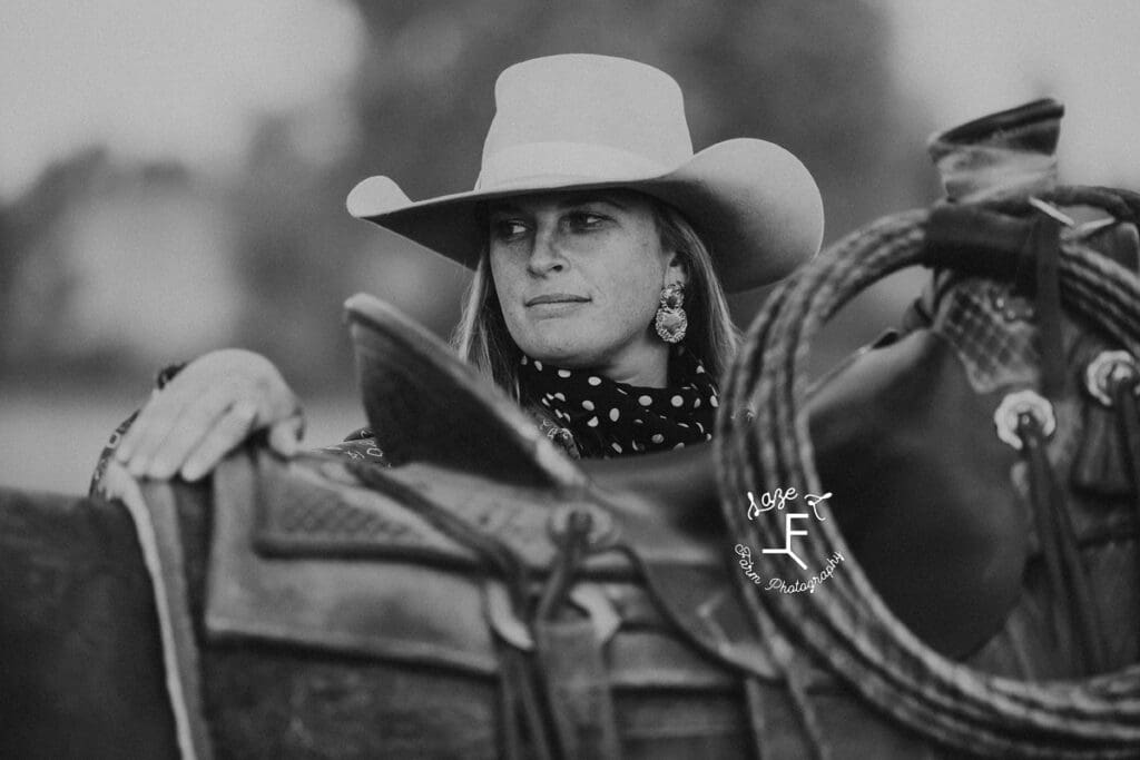 Cowgirl 1 looking over saddle in black and white