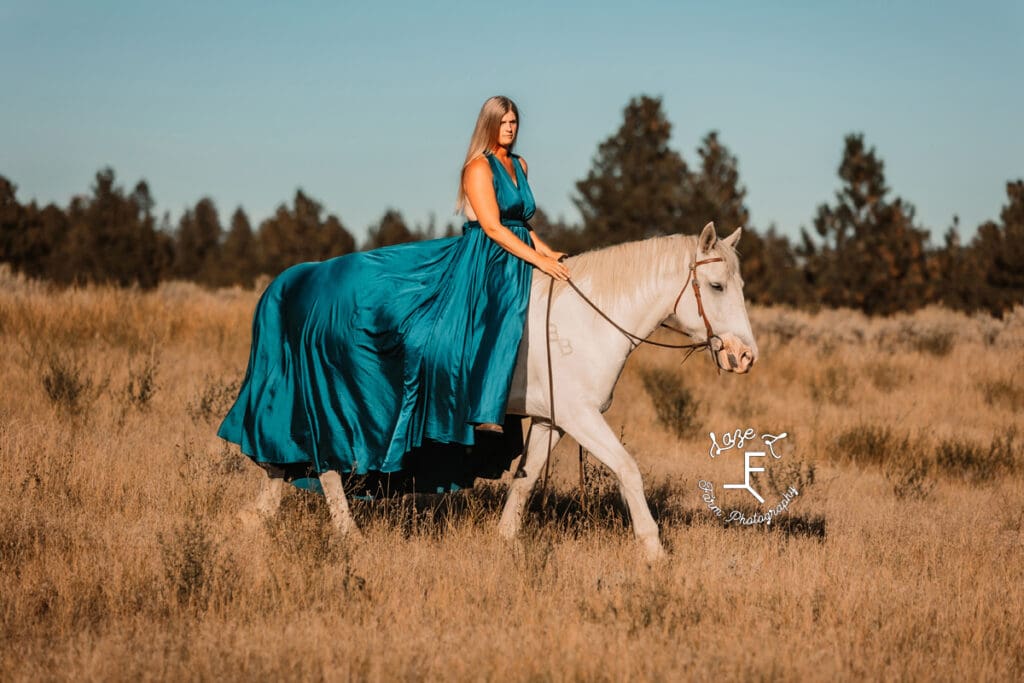 Cowgirl 1 riding grey horse in turquoise dress