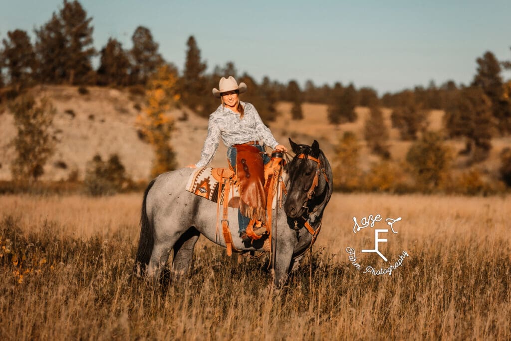 Cowgirl 2 sitting on roan horse