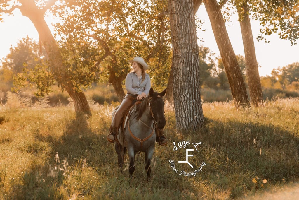 Cowgirl 2 on roan horse in field looking left