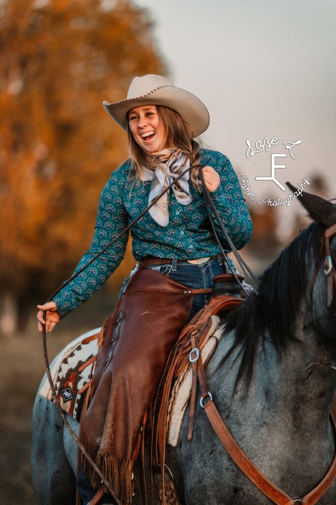 Cowgirl 2 in blue button down on roan horse