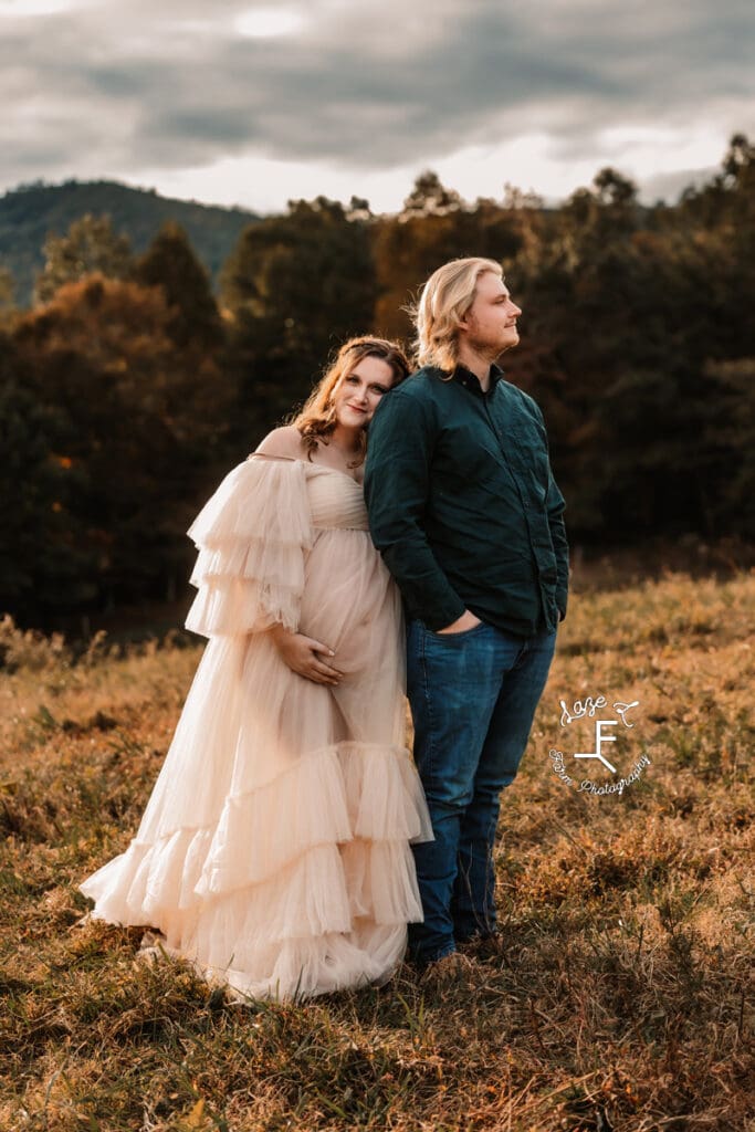 Ashley standing behind Devin holding bump