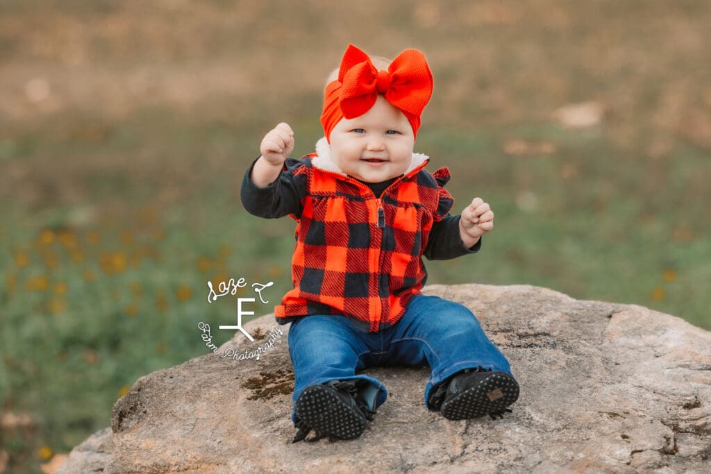 Baby sister sitting on rocks