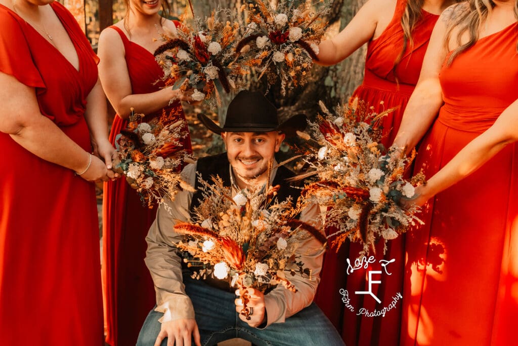 bridesmaids making flower frame around groom