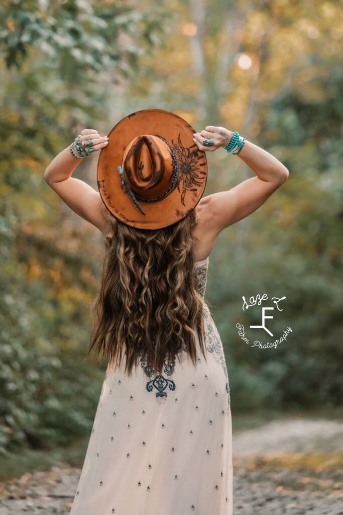 Wendy facing away from camera tipping head up to see hat