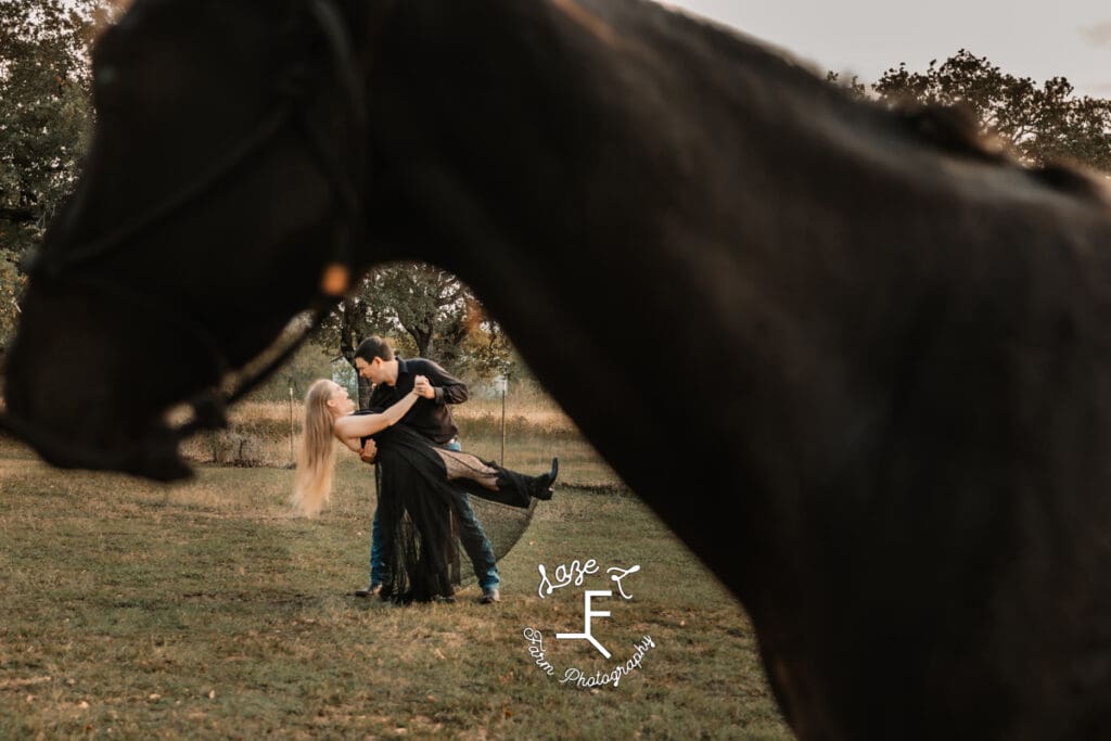 husband and wife dipping with horse in foreground