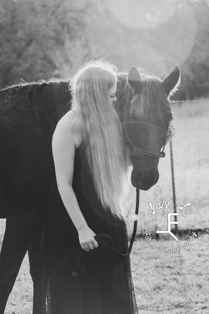 Danielle with black horse in black and white