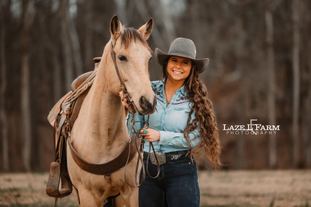 cowgirl standing beside her horse
