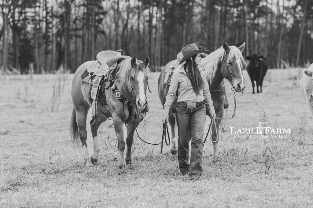 cowgirl walking with her two horses
