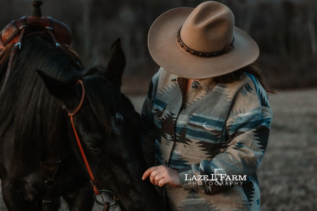 cowgirl standing beside her horse