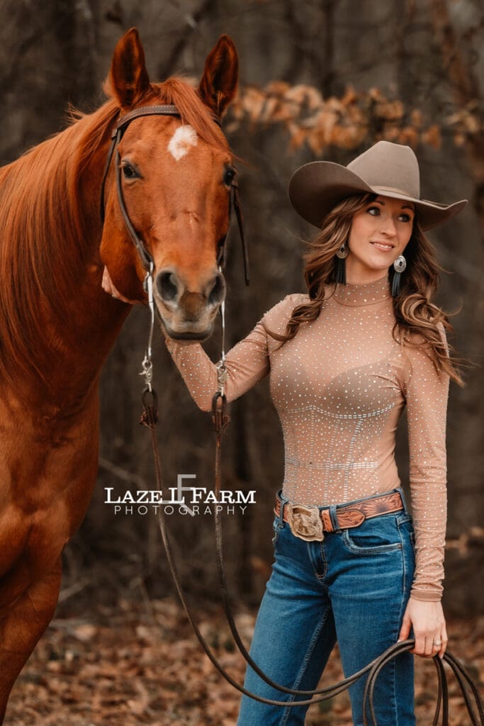 cowgirl standing beside her horse