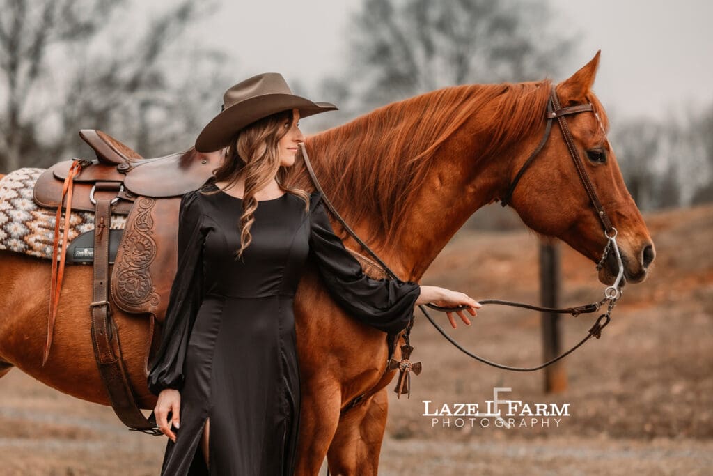 cowgirl standing beside her horse