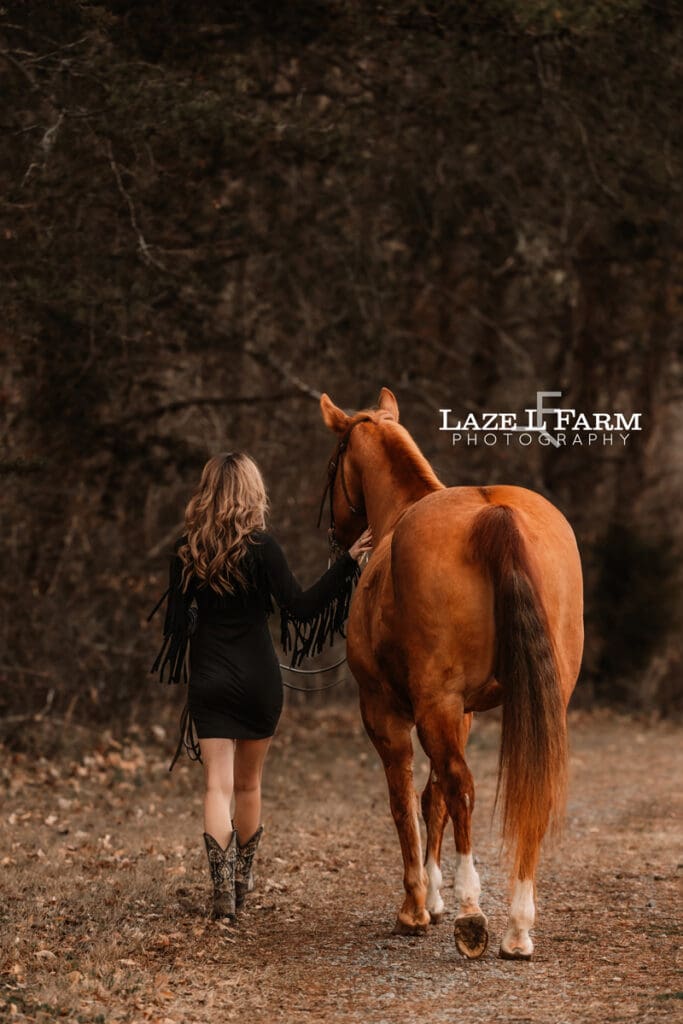 girl walking away with horse