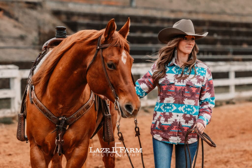 cowgirl standing beside of horse