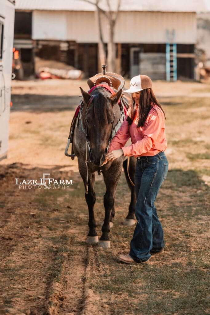 cowgirl bridling her horse