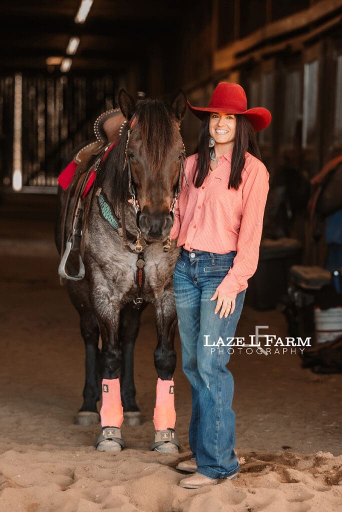 cowgirl standing beside her horse
