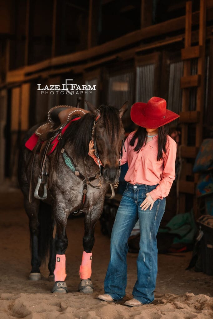 cowgirl in barn with her horse