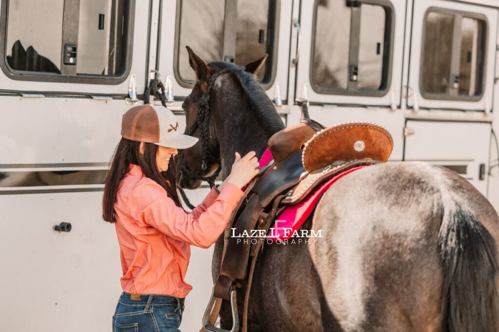 cowgirl saddling her horse