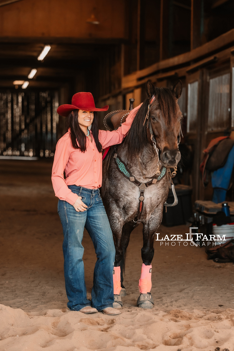 cowgirl standing beside her horse